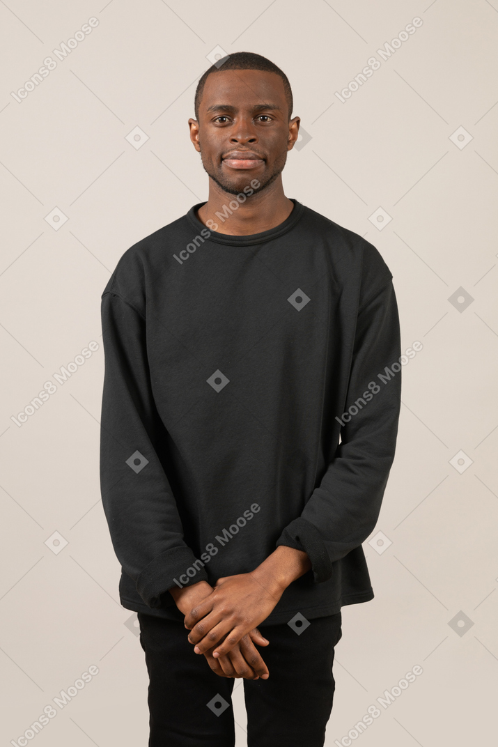 Young man standing with folded hands