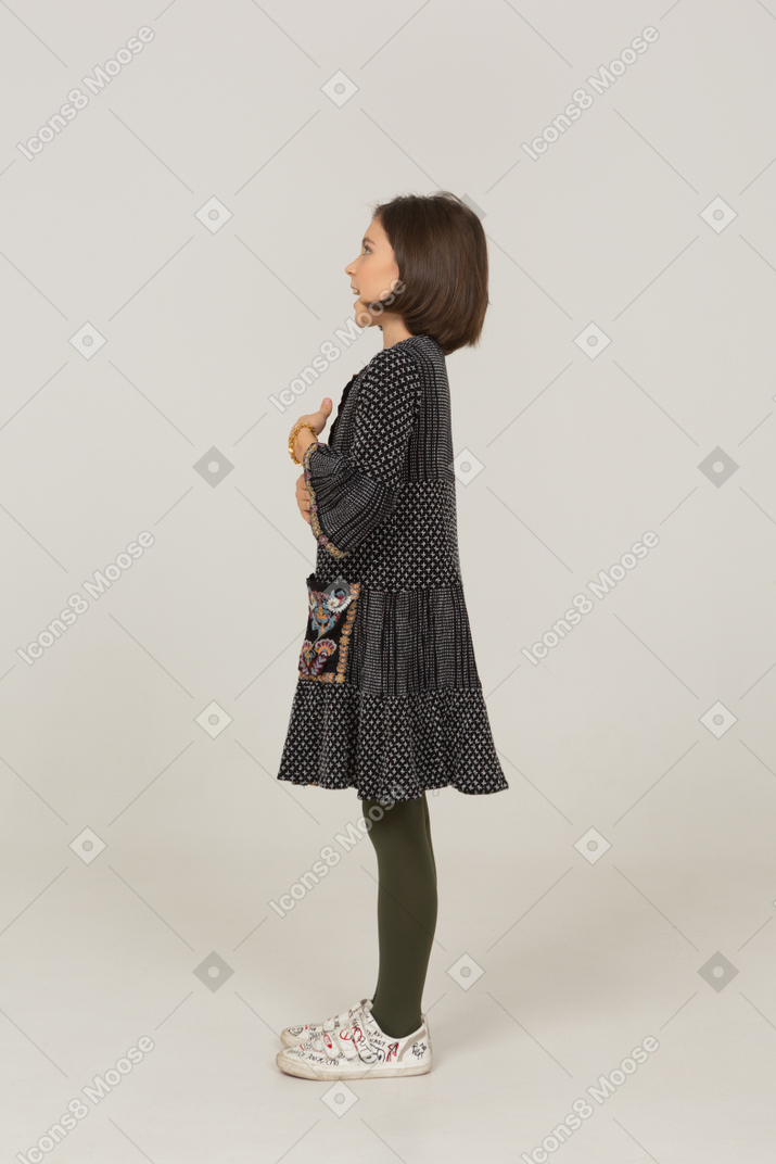 Side view of a gesticulating talking little girl in dress