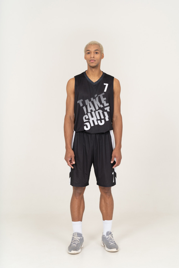 Front view of a young male basketball player standing still & looking at camera