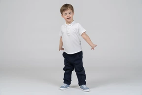 Little boy standing with arms at sides