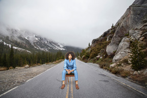 Homme assis sur une chaise dans les montagnes