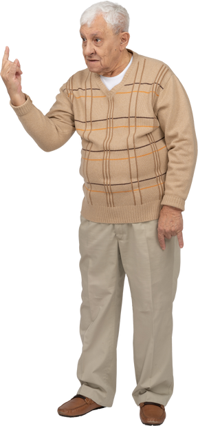Vista frontal de un anciano con ropa informal que muestra un gesto de roca
