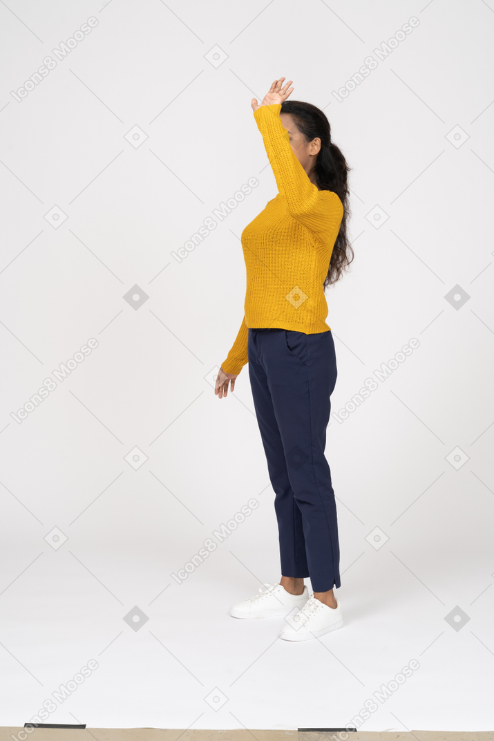 Side view of a happy girl in casual clothes waving
