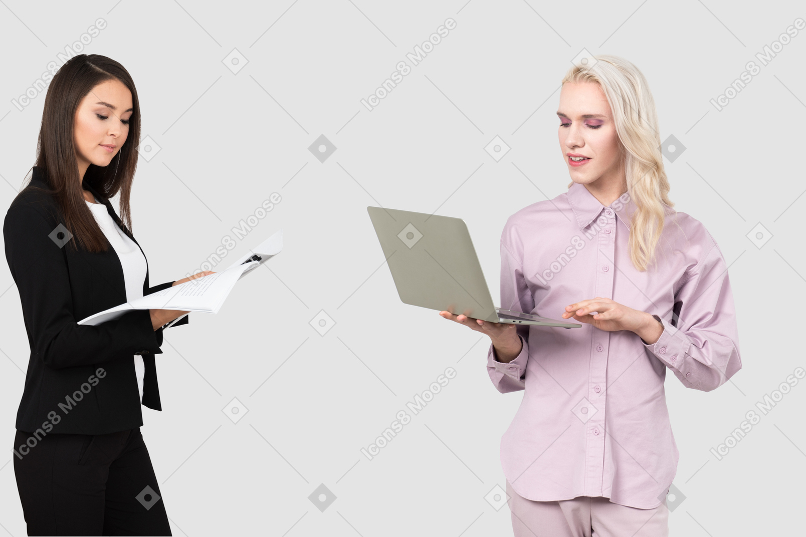 Woman and person standing next to each other with laptops