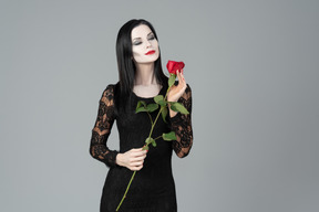 Morticia addams che odora la rosa rossa