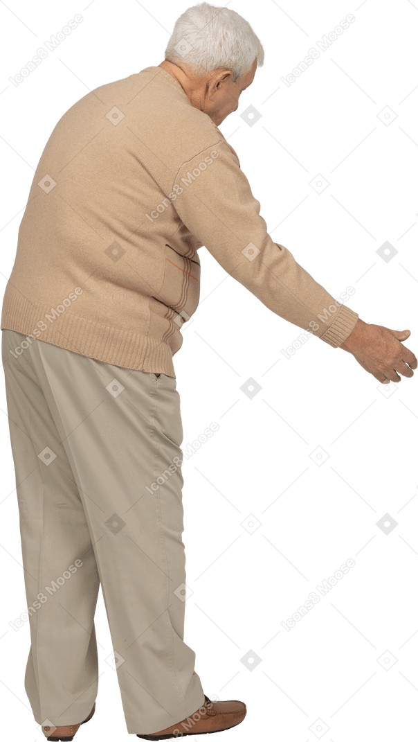 Side view of an old man in casual clothes making welcoming gesture