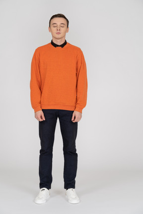 Young man in orange sweatshirt standing