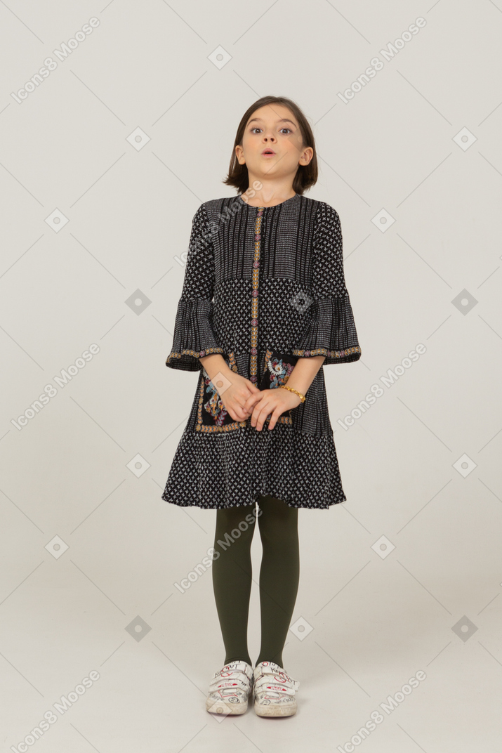 Vista frontal de una niña confundida en vestido inclinado hacia atrás