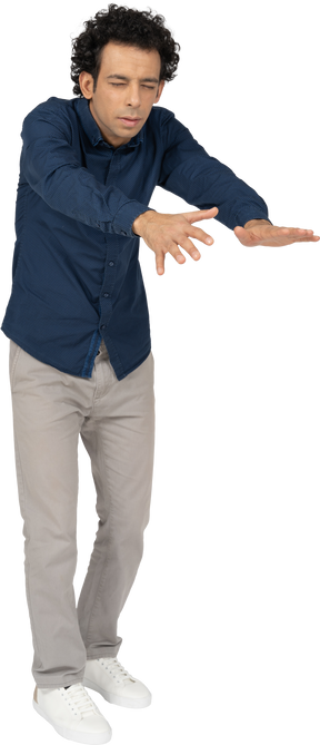 Vista frontal de um homem com roupas casuais em pé com os braços estendidos