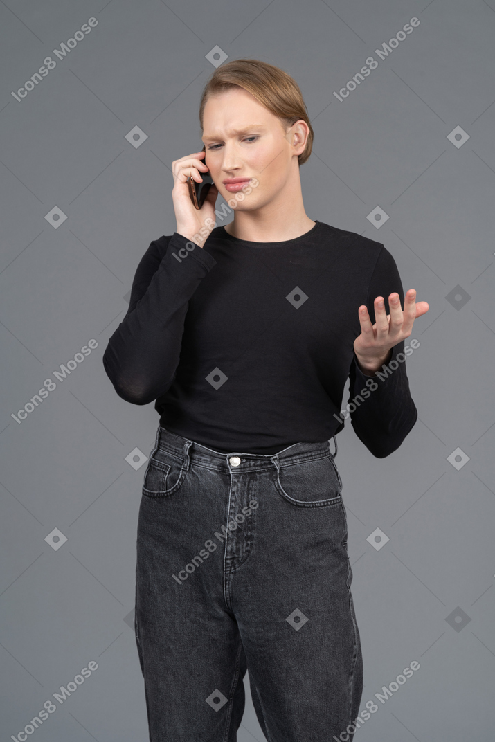 Persona confundida haciendo gestos mientras habla por teléfono.
