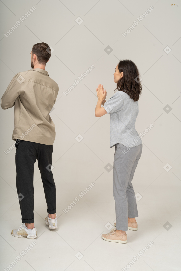 Vista lateral do homem e da mulher com as mãos postas