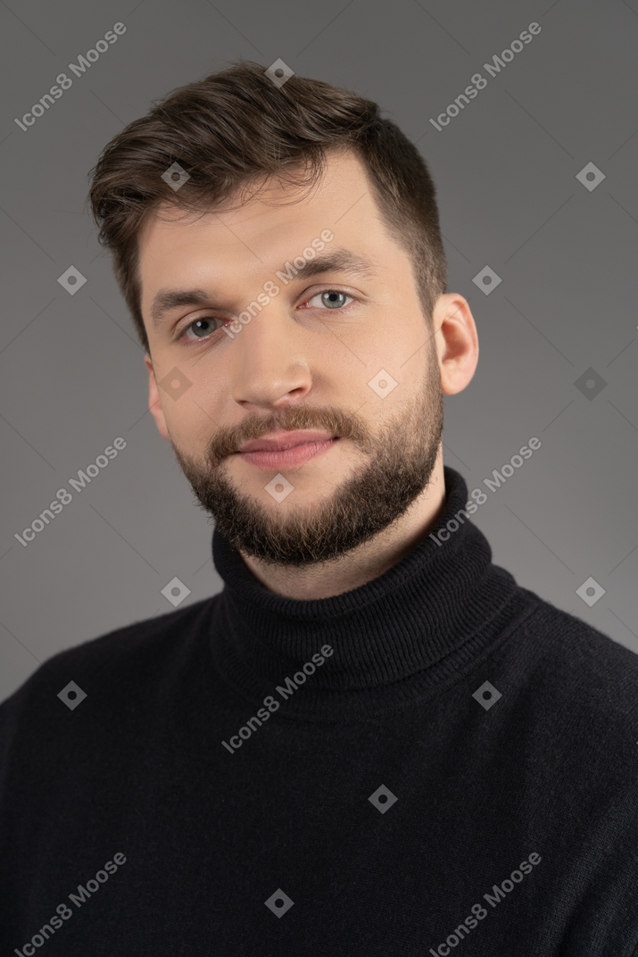 Portrait of a young bearded man isolated over gray background