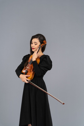 Close-up of a young lady in black dress holding the violin