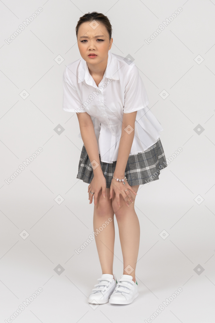 Uma menina asiática cética, curvando-se para a frente
