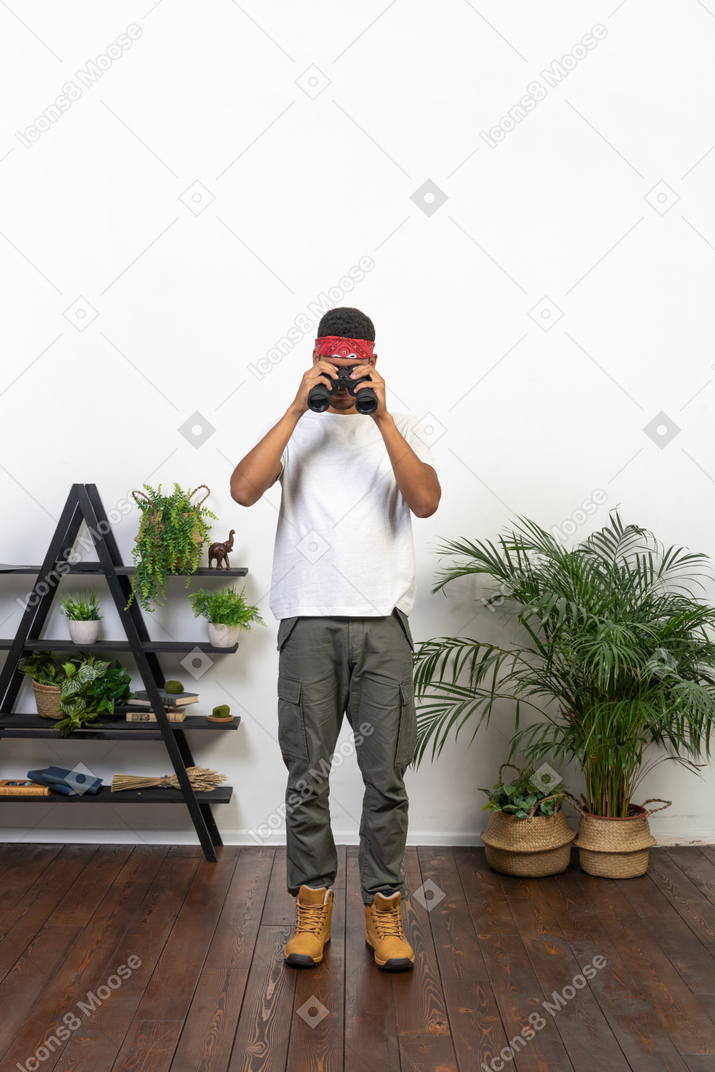 Good looking young man holding binoculars