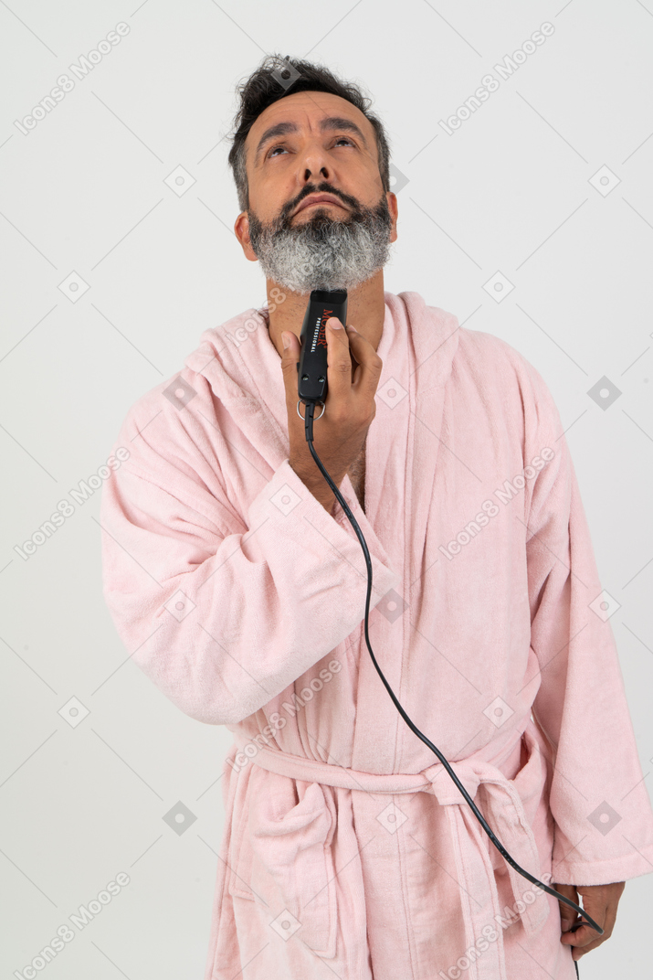 Mature guy shaving his beard with an electric razor