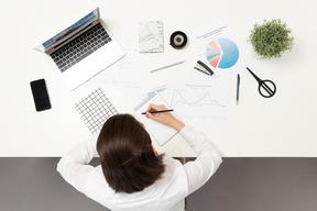 Um trabalhador de escritório feminino fazendo anotações na mesa