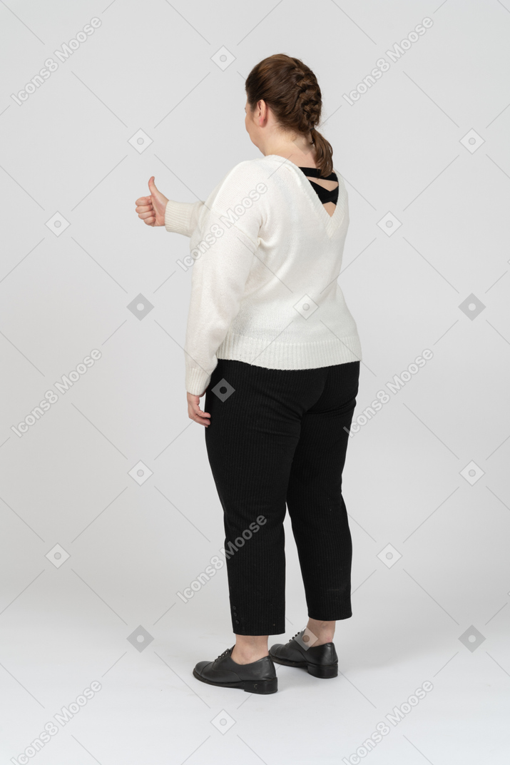 Plus size donna in maglione bianco che mostra il pollice in su