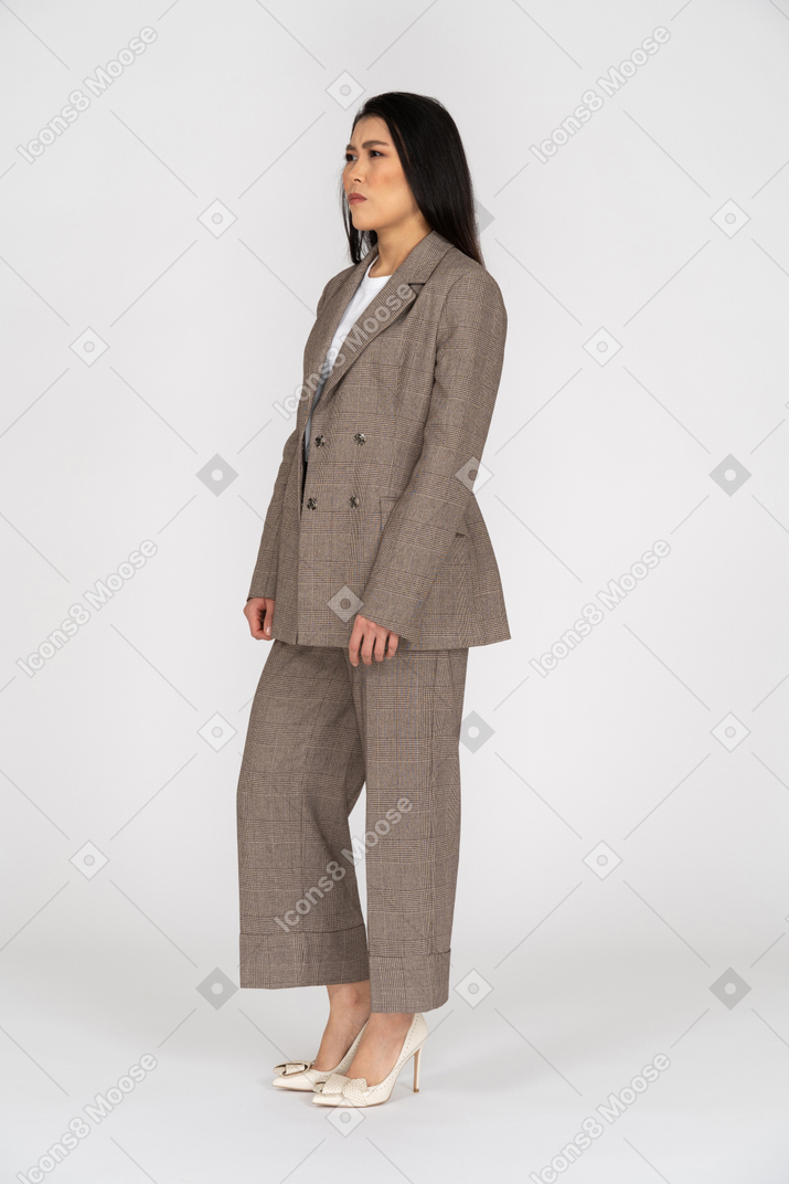Three-quarter view of a suspicious young lady in brown business suit