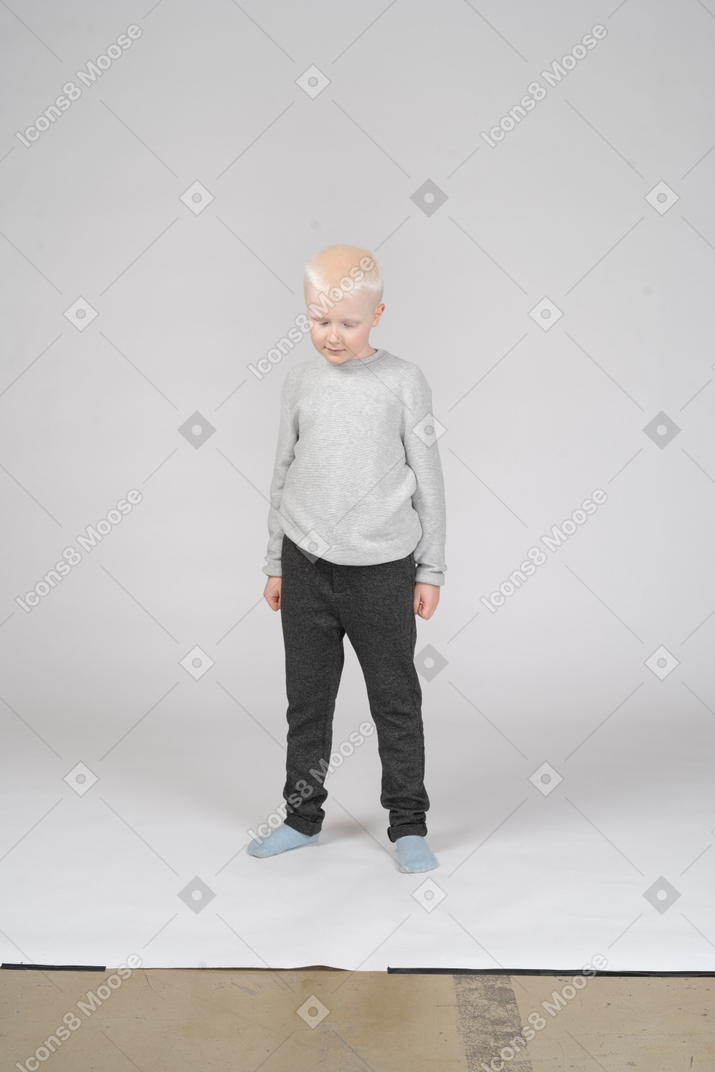Front view of a shy little boy looking down