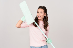 Attractive young woman holding a mop