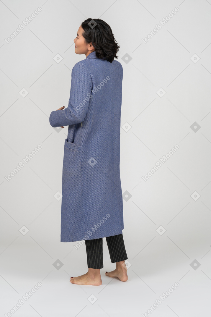 Vista posteriore di una donna in cappotto in piedi