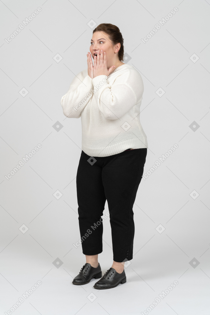 Удивленная пухлая женщина в повседневной одежде стоя в профиль