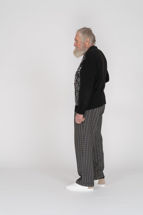 カジュアルな服装で立っている老人の側面図