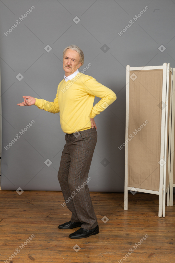 Side view of a grimacing old man with a back pain