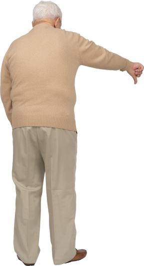 Vista posteriore di un uomo anziano in abiti casual che mostra il pollice verso il basso