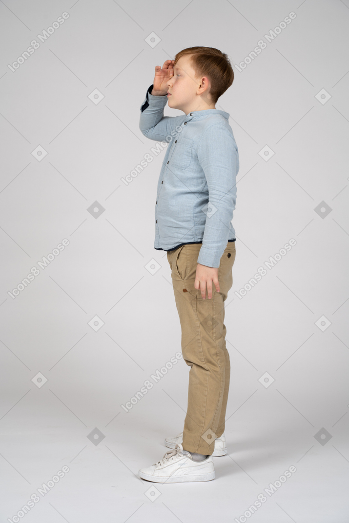 Side view of a boy looking for someone
