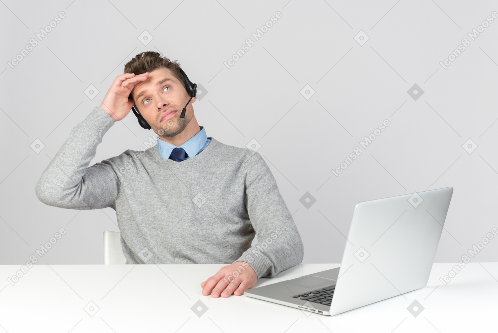 Call center agent sitting at office desk and looking up