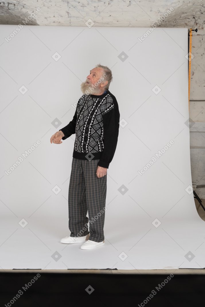 Old man looking up with slightly raised arm