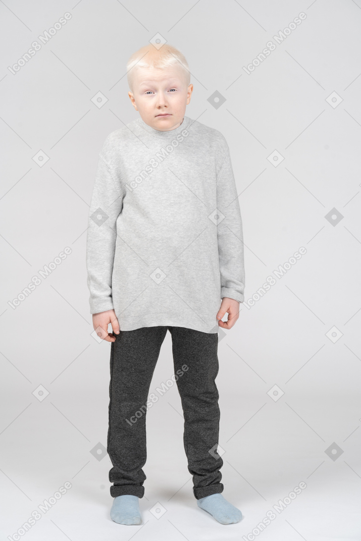 Front view of a kid boy in casual clothes with a funny face