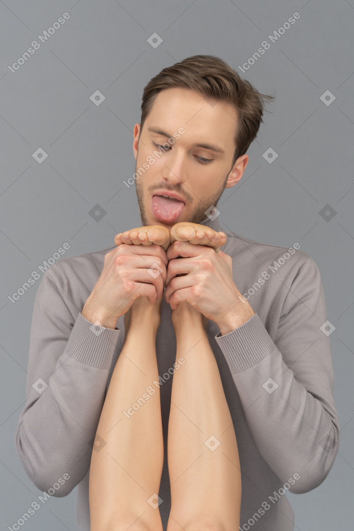 A young man is about to lick woman`s feet Photo