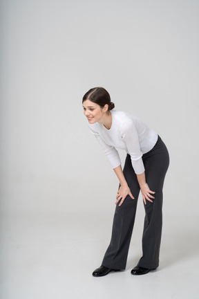 Front view of a woman in suit bending down