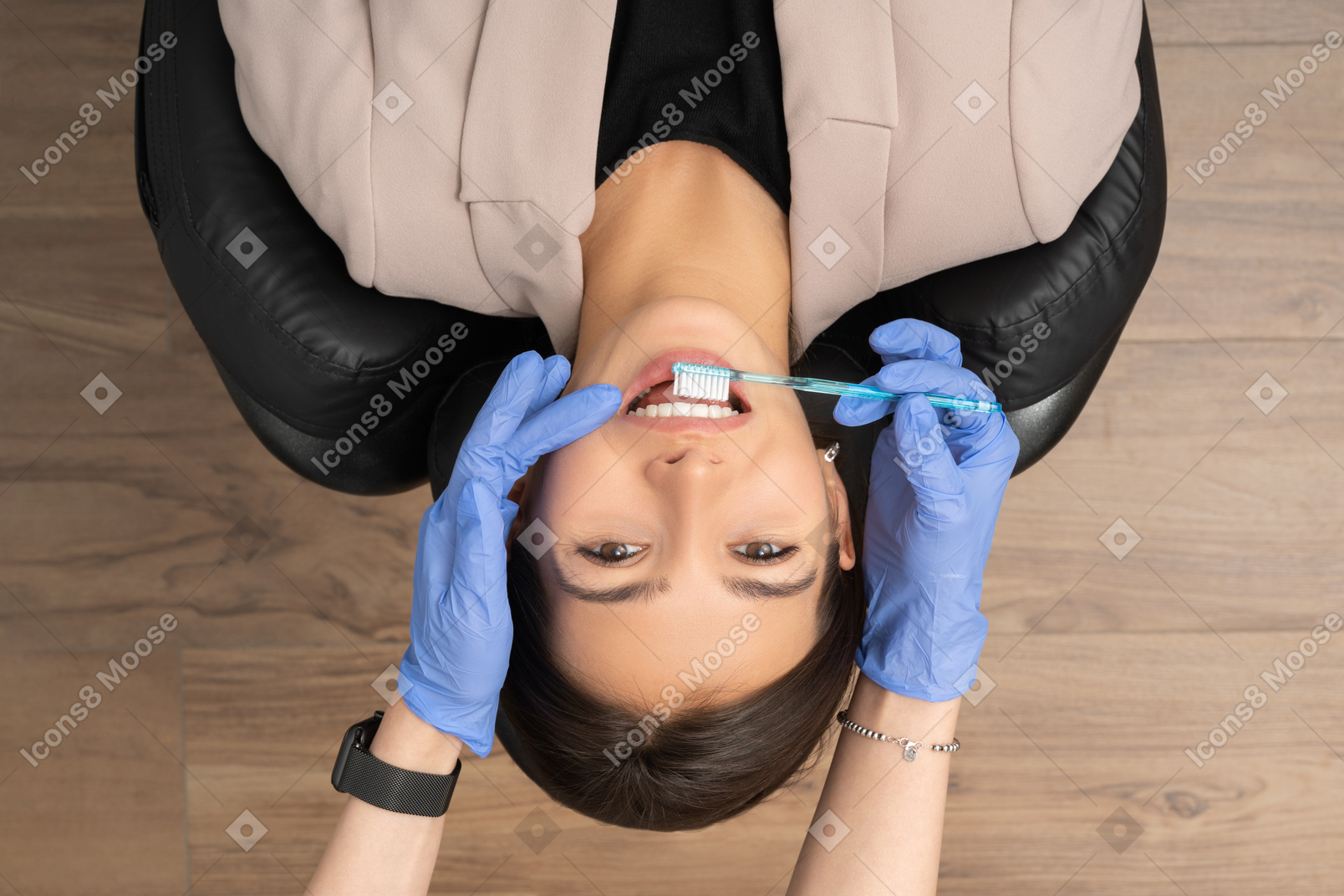 Female at the dentist chair brushing teeth