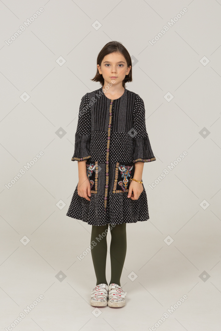 Front view of a little girl in dress looking at camera