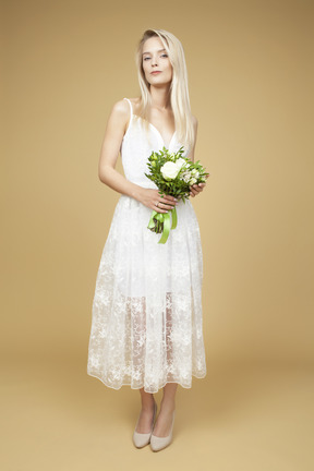 拿着花束和摆在为图片的美丽的新娘