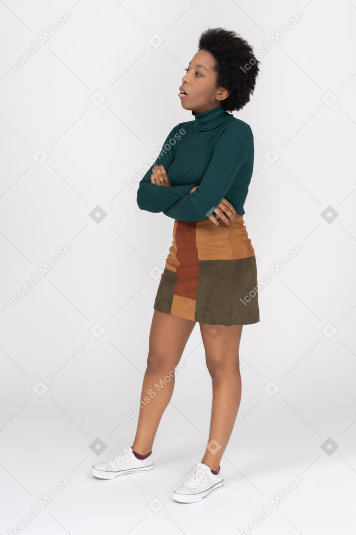 Garota africana irritada em pé com os braços cruzados