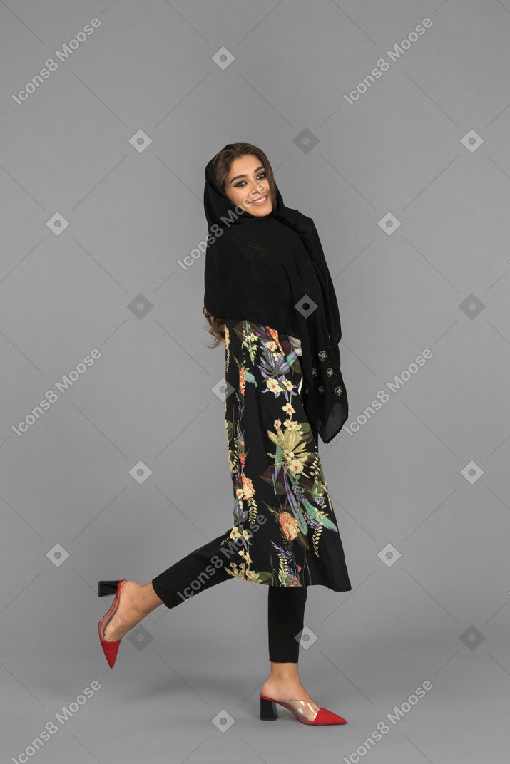 Smiling covered muslim woman lifting one leg