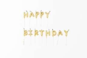 Golden letter candles on a white background