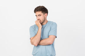 Young man looking anxious and biting his nails