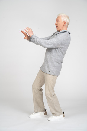 Side view of a man standing and reaching arms out