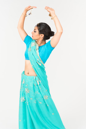 Young indian woman in blue sari standing in dance position