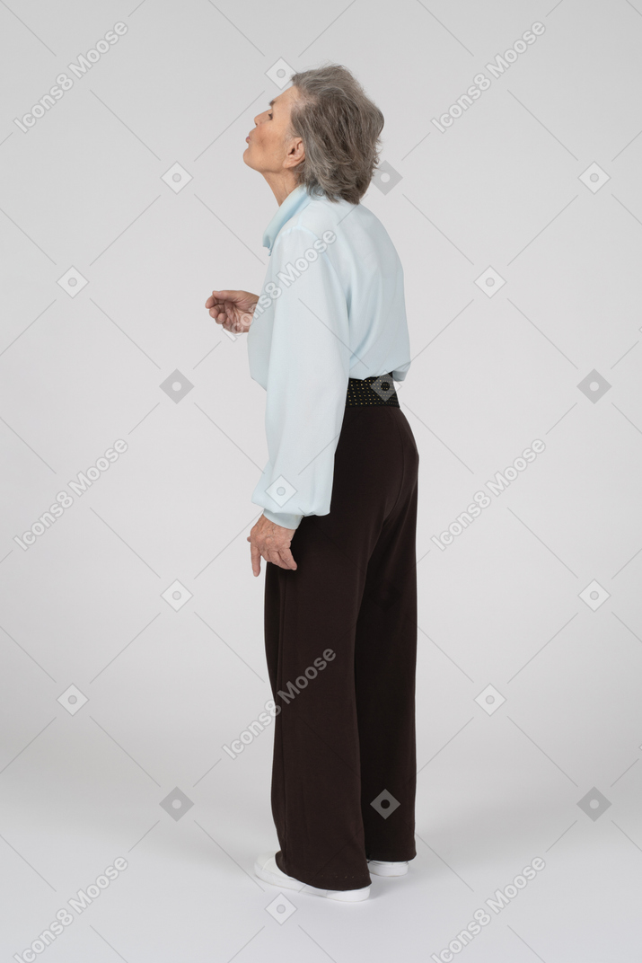 Vista posteriore di una donna anziana che fa una faccia baciata