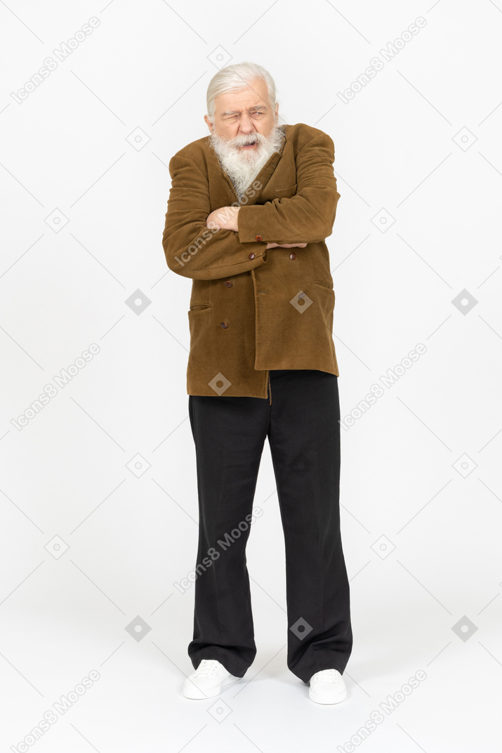 Elderly man with arms crossed, looking grumpy