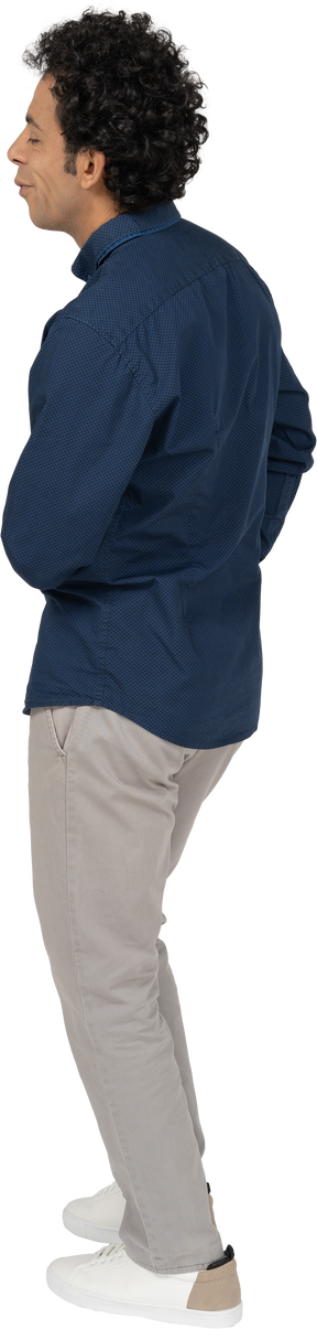 Seitenansicht eines mannes in freizeitkleidung, der mit der hand auf der brust posiert