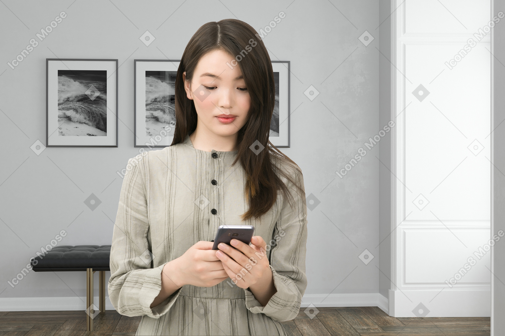 A woman standing in a room looking at her cell phone