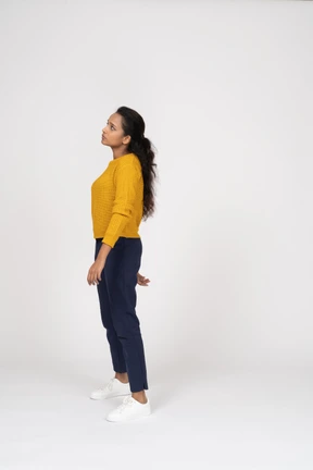 Thoughtful girl in casual clothes posing in profile and looking up
